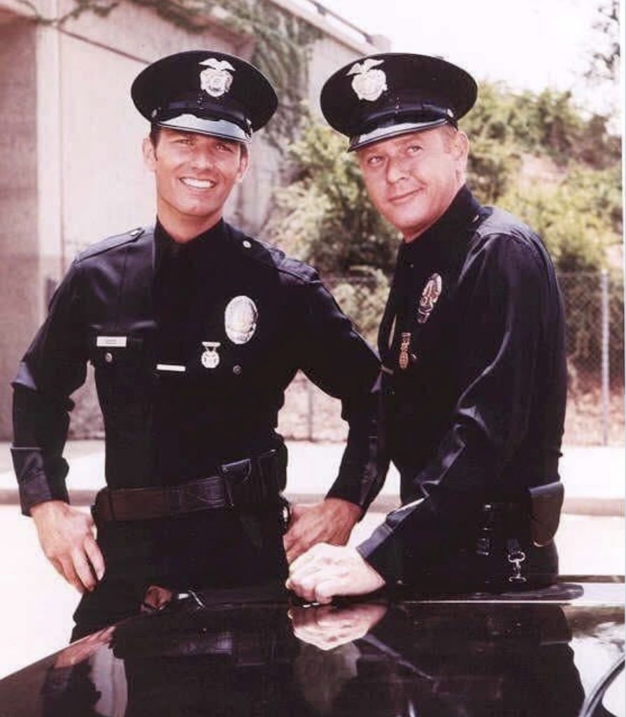 Two police officers in uniform, standing.